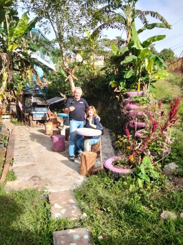 a man and a child standing in a garden at Cbaz bungalow house in Sagada
