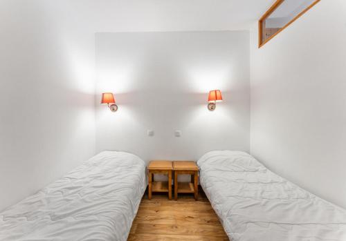 une chambre avec deux lits et une table dans l'établissement Résidence Les Hauts De Preclaux - Chaleureux studio avec balcon face aux pistes MAE-4451, aux Orres