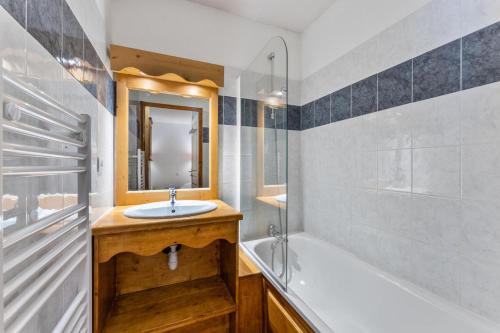 une salle de bain avec une baignoire et un lavabo et une baignoire dans l'établissement Résidence Les Hauts De Preclaux - Chaleureux studio avec balcon face aux pistes MAE-4451, aux Orres