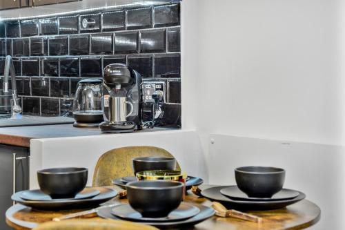 a table with plates and cups on top of a kitchen at ABBAccommodation in London