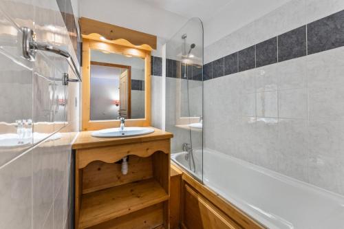 une salle de bain avec un lavabo, une baignoire et un miroir dans l'établissement Résidence Les Hauts De Preclaux - Appartement ensoleillé avec vue sur les pistes MAE-6931, aux Orres