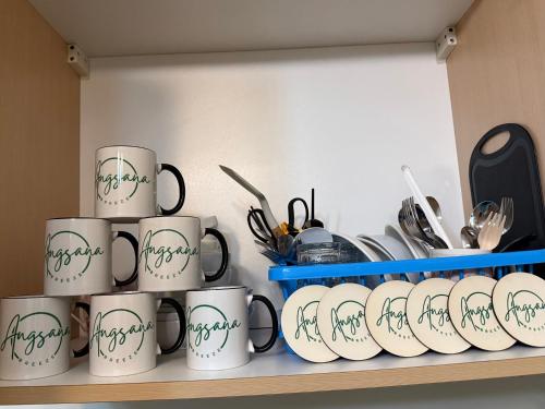 a bunch of coffee mugs sitting on a shelf at Angsana Breeze at Paseo Verde Las Piñas in Manila