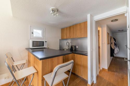 - une cuisine avec un comptoir et un four micro-ondes dans l'établissement Résidence Le Cristal - Très beau 3 pièces en duplex dans le centre de Méribel proche des commerces et des pistes de ski MAE-4931, à Les Allues