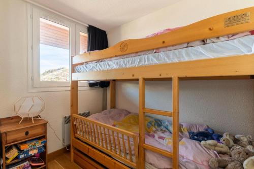 une chambre avec deux lits superposés et une fenêtre dans l'établissement Résidence Le Cristal - Très beau 3 pièces en duplex dans le centre de Méribel proche des commerces et des pistes de ski MAE-4931, à Les Allues