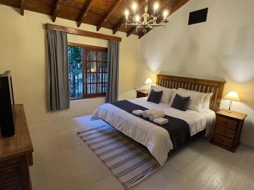 a bedroom with a large bed and a chandelier at Carmela Inn in Monte Grande