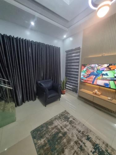 a living room with a chair and a tv at Stren Mulberry Apartments in Lagos