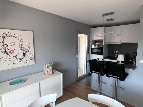 une cuisine avec une table et des chaises dans une pièce dans l'établissement Les Glycines, à Le Touquet-Paris-Plage