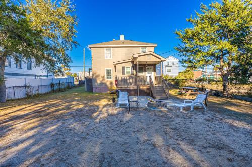 a house with chairs and a table in the yard at Dazzling Centrally Located Ocean View w 2 Kings, Huge Private Yard, 2 Decks, Firepit, BBQ in Myrtle Beach