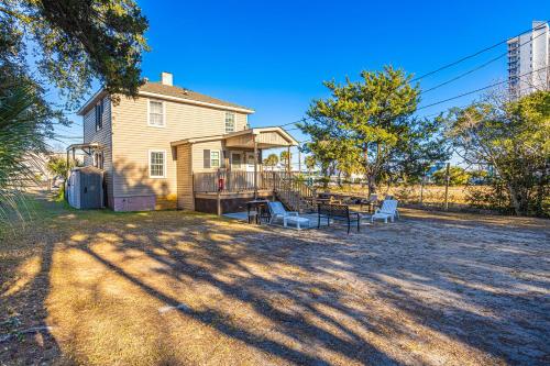 a house with a table and chairs in the yard at Dazzling Centrally Located Ocean View w 2 Kings, Huge Private Yard, 2 Decks, Firepit, BBQ in Myrtle Beach