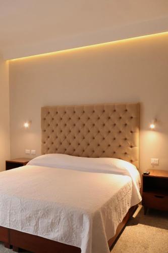 a bedroom with a large white bed and two tables at Casa San José in Coatepec