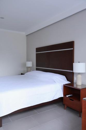 a bedroom with a large white bed and a wooden headboard at Casa San José in Coatepec