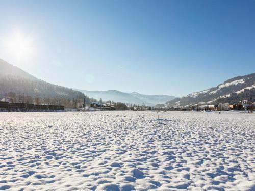 a snow covered field with mountains in the background at Brixen Alpin Living Top 9 und 10 in Brixen im Thale