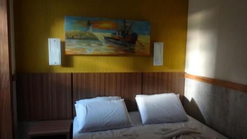 1 dormitorio con 1 cama con 2 almohadas y una pintura en Ancoradouro Hotel - Centro De Porto Seguro, en Porto Seguro