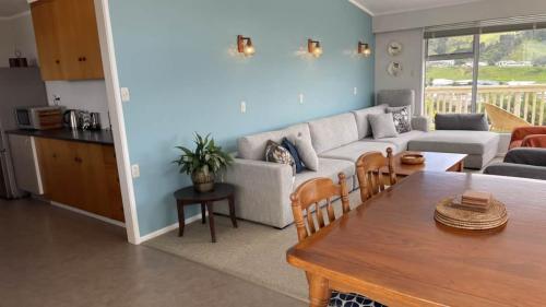 a living room with a couch and a table at Relax and rewind at Waihi Beach with Oberon Bach in Waihi Beach