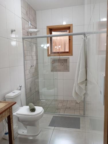 a white bathroom with a shower and a toilet at casa de mineiro in Tiradentes