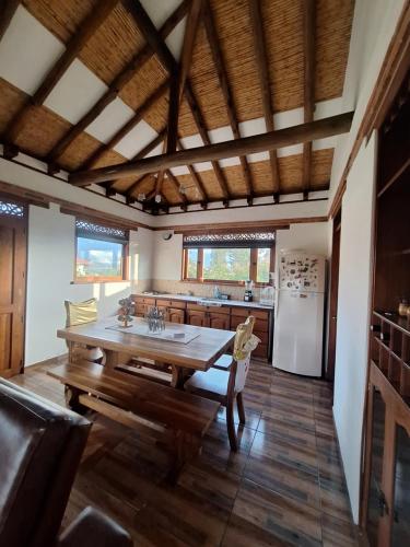a kitchen with a wooden table and a kitchen with a refrigerator at Casa Campestre Flores Amarillas in Villa de Leyva