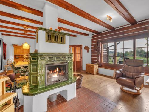 a living room with a fireplace and a chair at Villa in Czechia with Heated Pool & Mountain Views in Vidochov