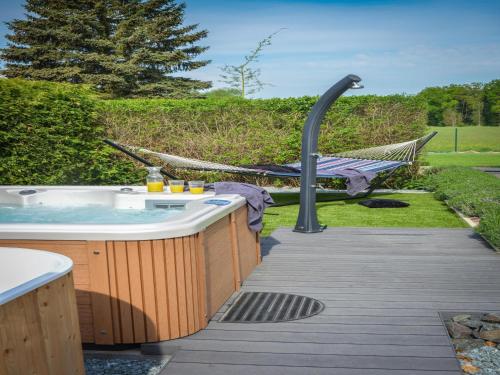 a hot tub in a yard with a hammock at Chalet in Roprachtice near Ski Slopes in Řečany nad Labem