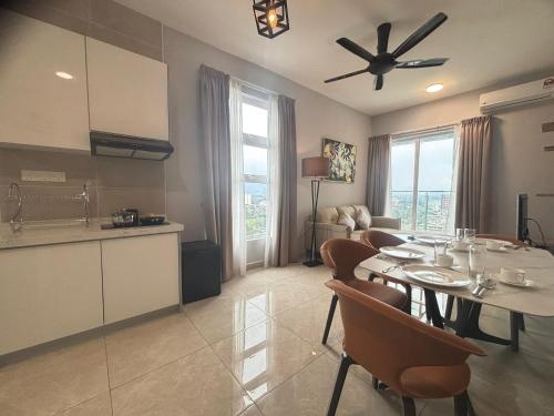 a kitchen and a dining room with a table and chairs at ICC Suites Ipoh City Centre in Ipoh