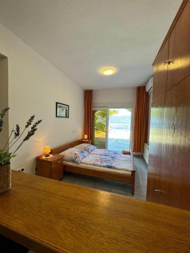 a bedroom with a bed and a large window at Apartments by the sea Slatine, Ciovo - 1139 in Slatine