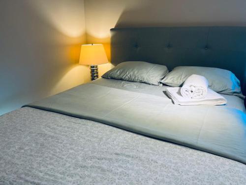 a bed with a towel and a book on it at Bedrooms in Kenaston, Close to Walmart, Costco, IKEA, Outlet, Unversity of Manitoba in Winnipeg