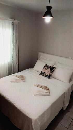 a large white bed with two napkins on it at Palmenhaus in Pomerode