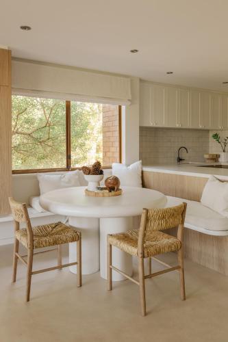 a kitchen with a table and two chairs and a counter at Scarborough Beach Retreat in Perth