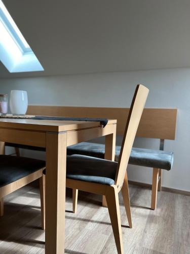 a dining room table with two chairs and a wooden table at NEUES appartment LOVE&LIGHT in Ollersdorf im Burgenland