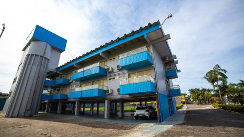 a building with blue balconies on the side of it at Rota do Sol Apart Hotel in Guaratuba
