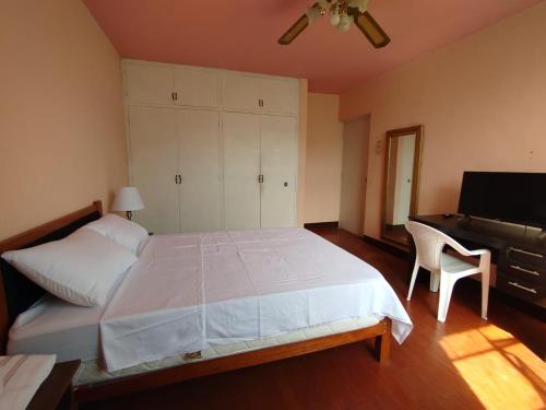 a bedroom with a large bed with a desk and a chair at Hotel Los Ebanos in Piura