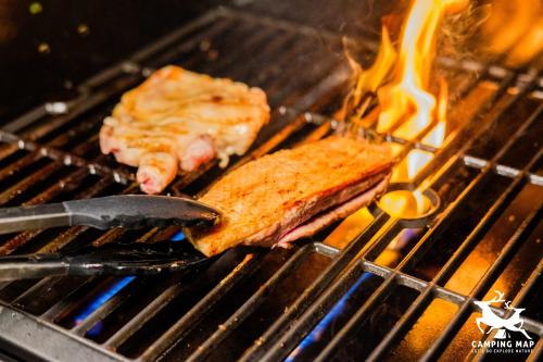 two pieces of food cooking on a grill with a spatula at 99Glamping in Douliu