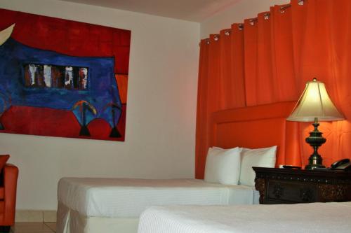 a hotel room with two beds and a painting on the wall at La Posada del Arcangel in Managua