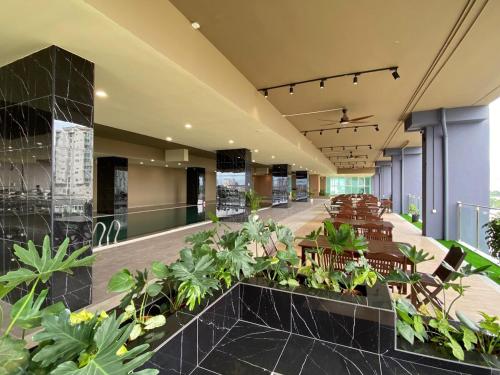 een lobby met tafels, stoelen en planten bij Wyndham Garden Suites IPOH ICC in Ipoh