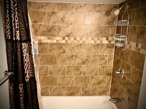 a bathroom with a shower with a tiled wall at Downtown Riverview Loft in Detroit