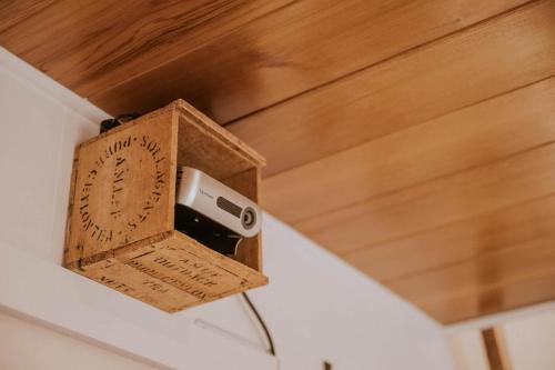reloj de madera en una pared con altavoz en The Crest - A Tiny House with a Big View, en Crackenback