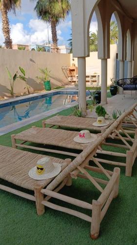 a group of lounge chairs sitting next to a swimming pool at Villa Marrakech piscine in Marrakech