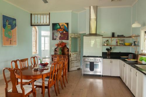 a kitchen with a table and chairs and a stove at Byron Homestead in Ewingsdale