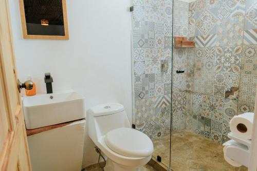 a bathroom with a toilet and a shower at Bonding Coffee Roaster Café & Hotel in Quepos