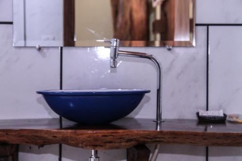 een wastafel in de badkamer met een kraan en een blauwe kom bij Pousada do Vovô in Fronteira