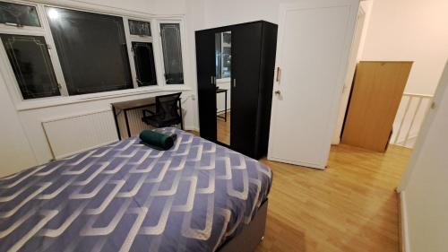 a bedroom with a bed and a desk in it at Guest house in Dagenham East by Fenia in Dagenham