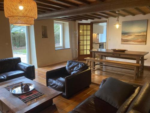 un salon avec un canapé et une table dans l'établissement Country House near Omaha Beach, à Asnières-en-Bessin