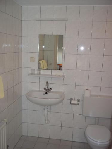 a white bathroom with a sink and a toilet at B&B Slaoperij in Orvelte