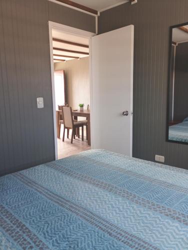 a bedroom with a bed and a dining room at Cabañas La Laguna de Zapallar in La Laguna Zapallar