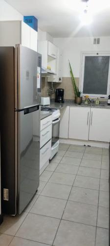 a kitchen with white cabinets and a stainless steel refrigerator at Monoambiente M y L in La Plata