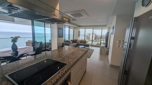 a kitchen with a view of a living room at Departamento Frente al Mar en Manta Poseidon in Manta