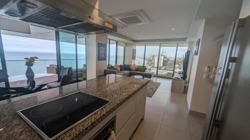 a kitchen and living room with a view of the ocean at Departamento Frente al Mar en Manta Poseidon in Manta