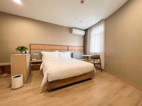 上海Shanghai Joyful Star Hotel-Free shuttle bus to Pudong Airport and Disneyland的一间带大床和书桌的卧室