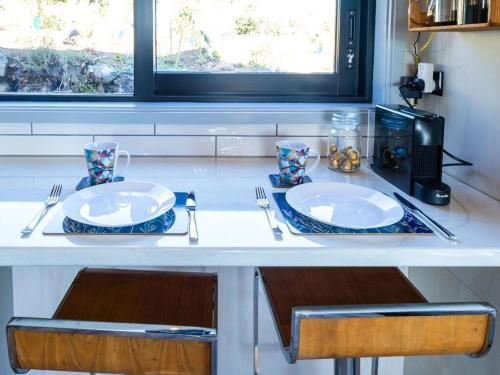 a table with two plates and utensils on it at Kūkupa Matairangi at Akaroa Lavender in Akaroa