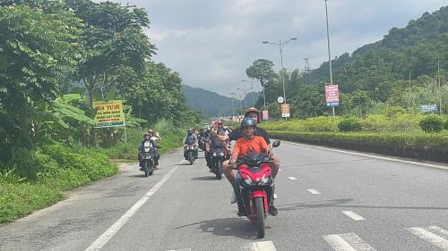 a group of people riding motorcycles down a road at Ha Giang Eco Bungalow in Ha Giang