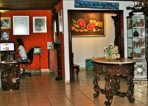 a woman sitting at a table in a room at La Posada del Arcangel in Managua